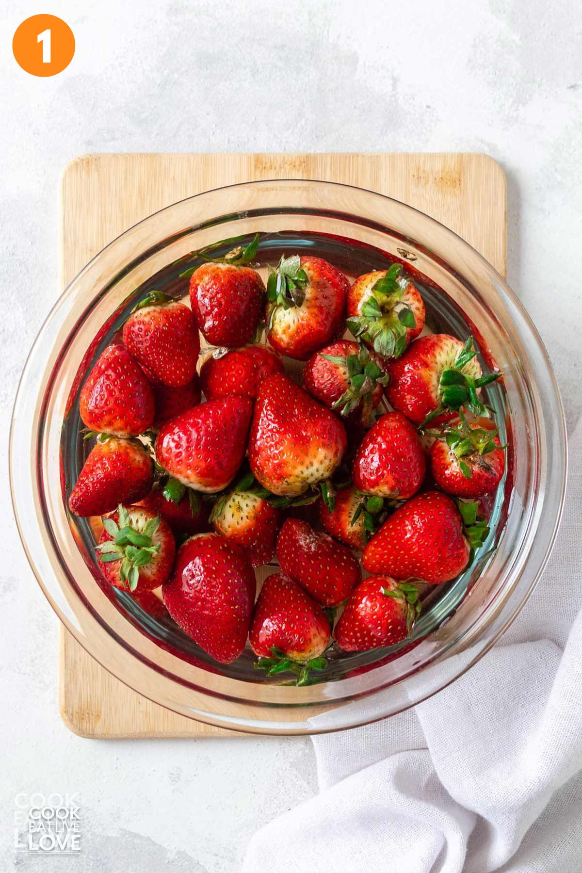 Strawberries in a bowl fo water.