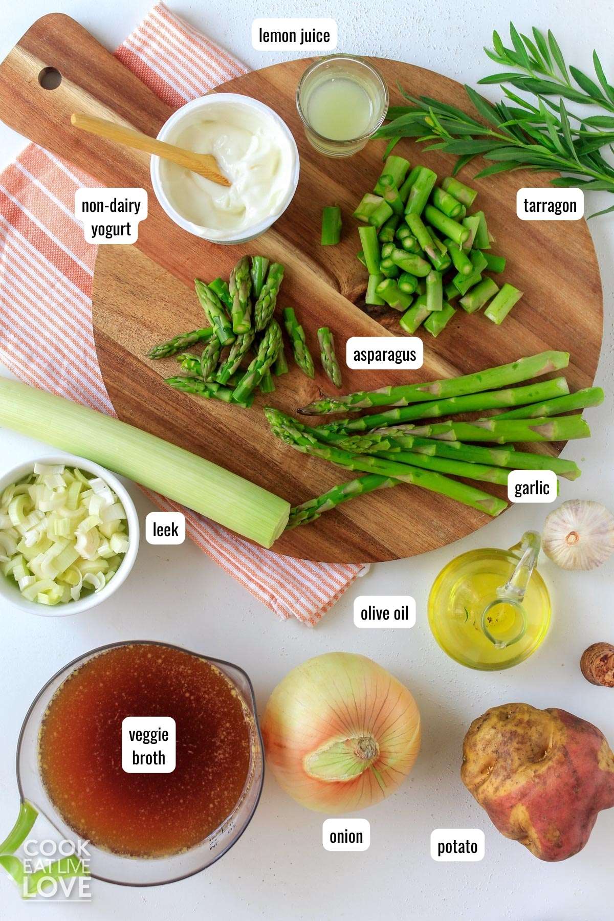 Ingredients to make vegan asparagus soup on a table with text labels.