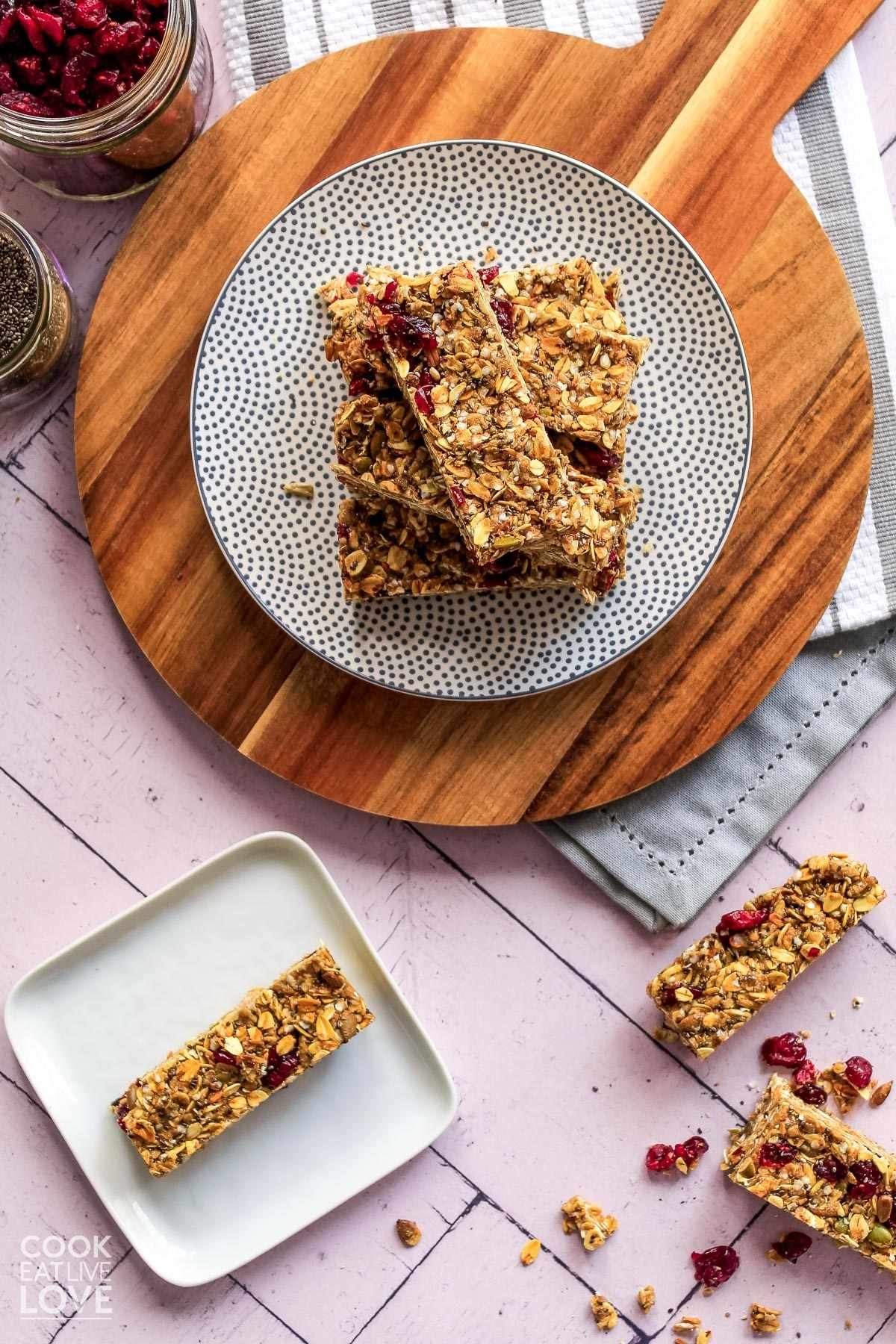 Homemade energy bars on a white and gray polka dotted plate on a round cutting board.