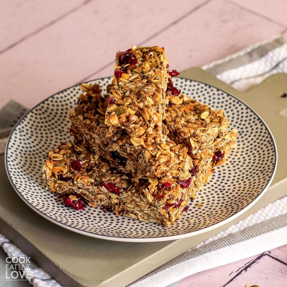 Vegan granola bars on a plate on a table with a pink background.
