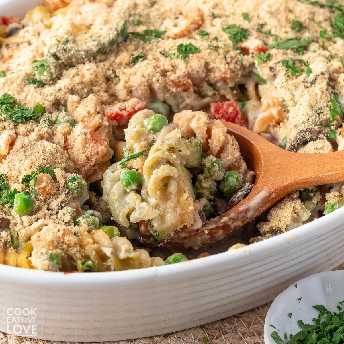 Vegan pasta bake served up on a blue and white plate with pot in background.