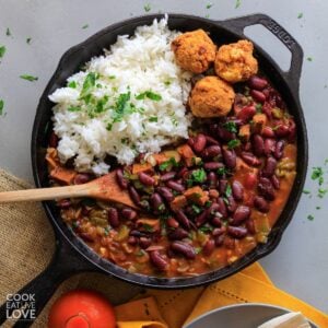 Bowl of red beans and rice with hushpuppies on a table