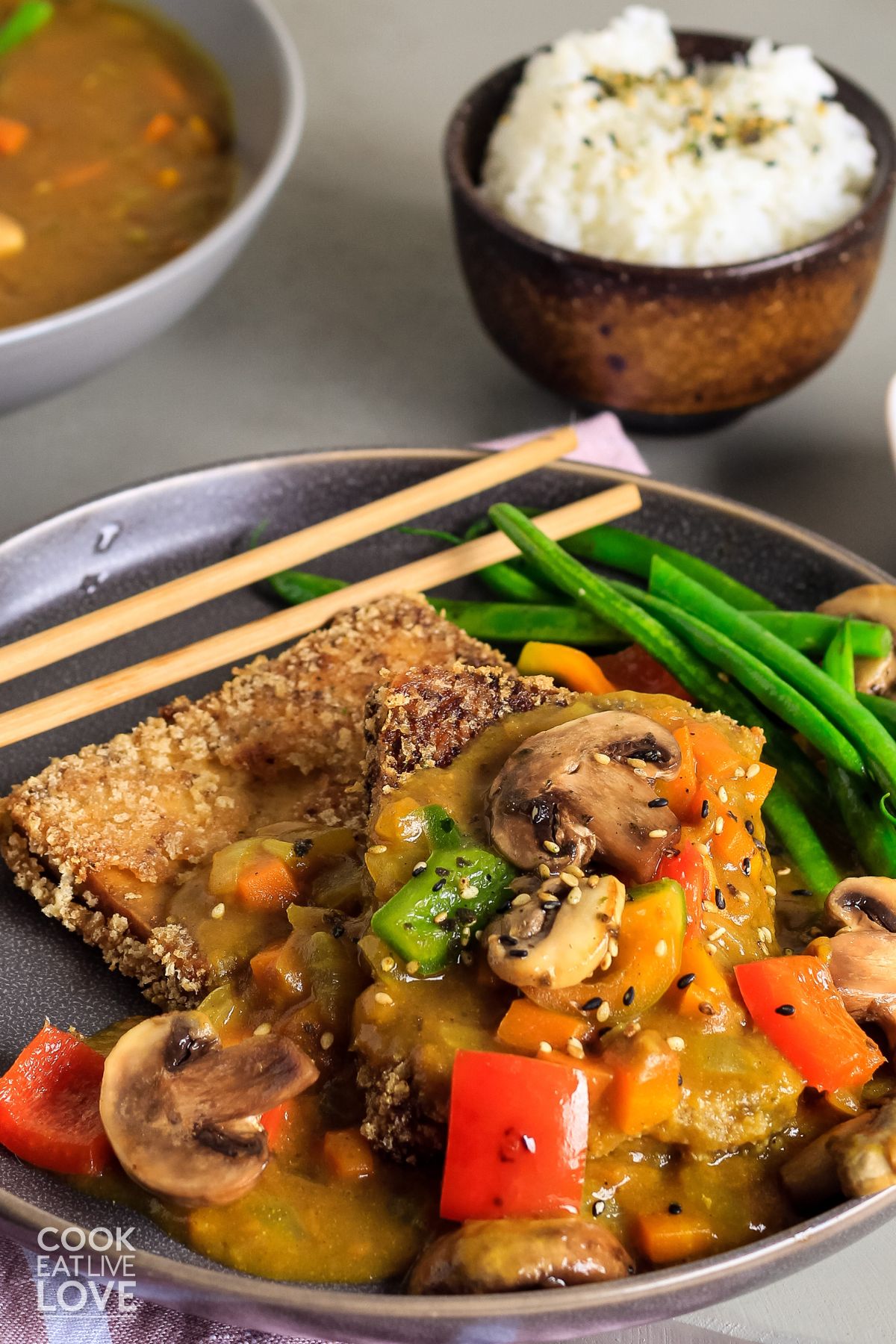 Vegetarian japanese curry served up with vegetables over a piece of crispy tofu.
