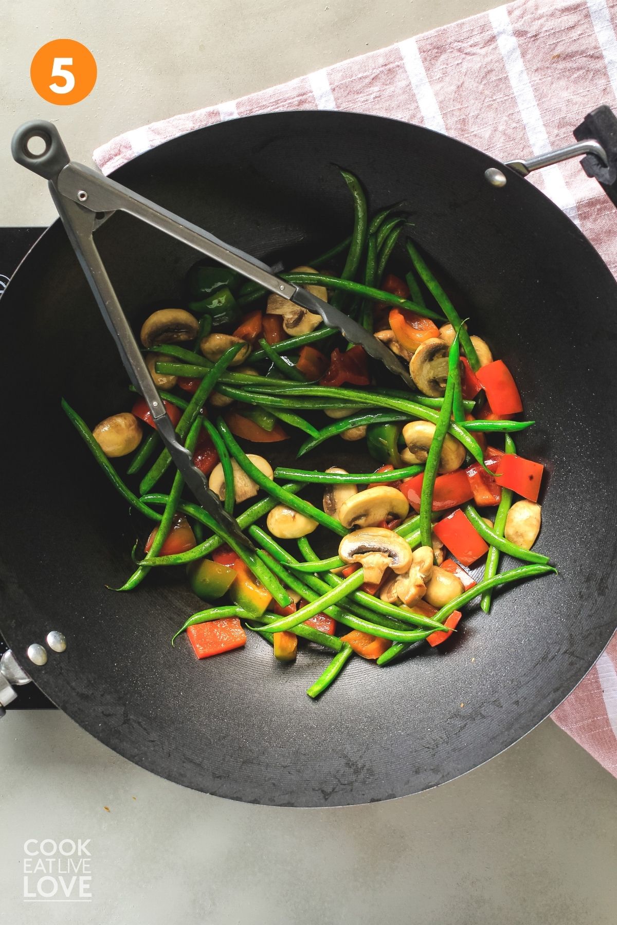 Vegetables are cooked in a wok.