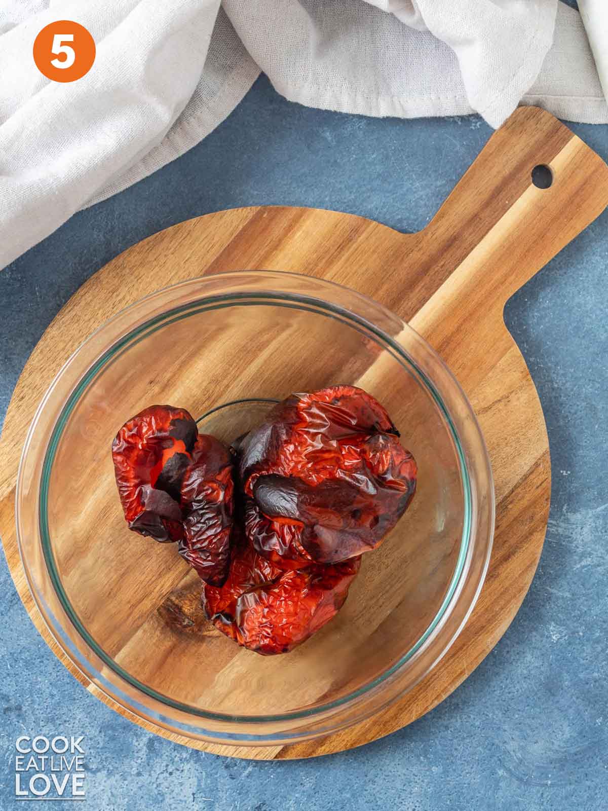 Roasted red peppers in a glass bowl after cooking.