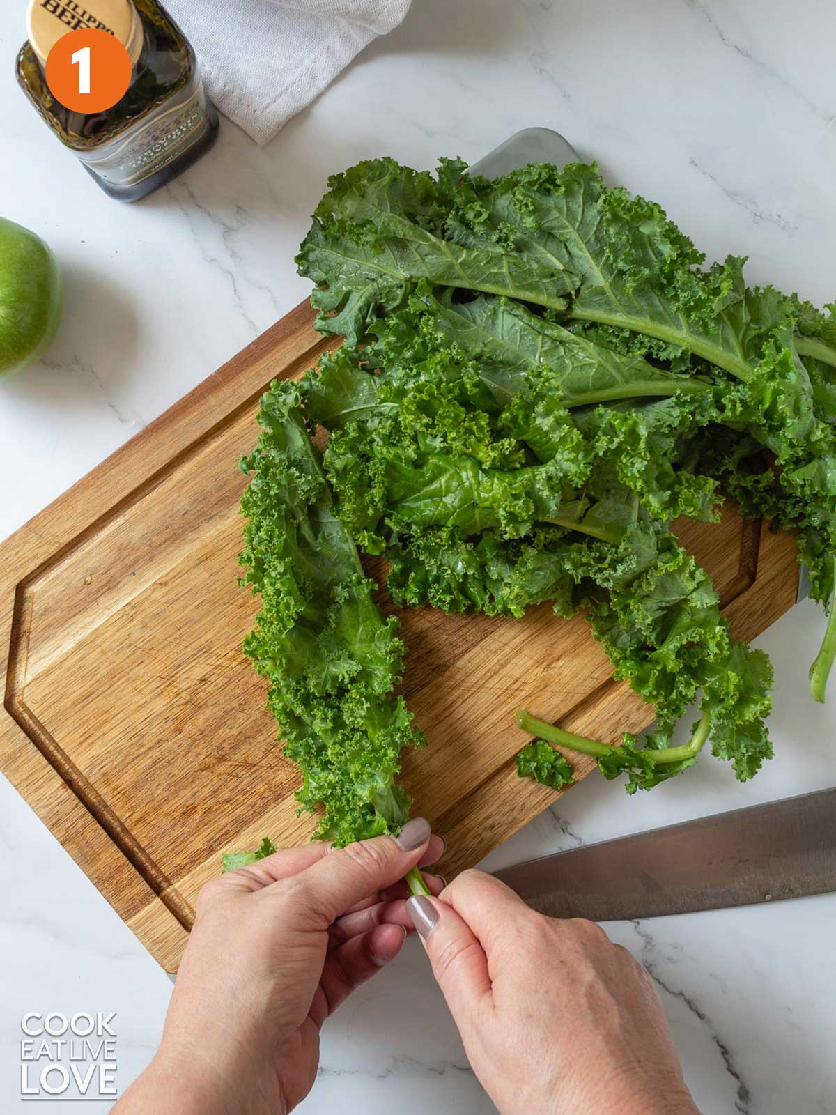 Peeling the leaves from a piece of kale.
