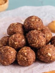 A stack of peanut butter oatmeal balls on a piece of white parchment.
