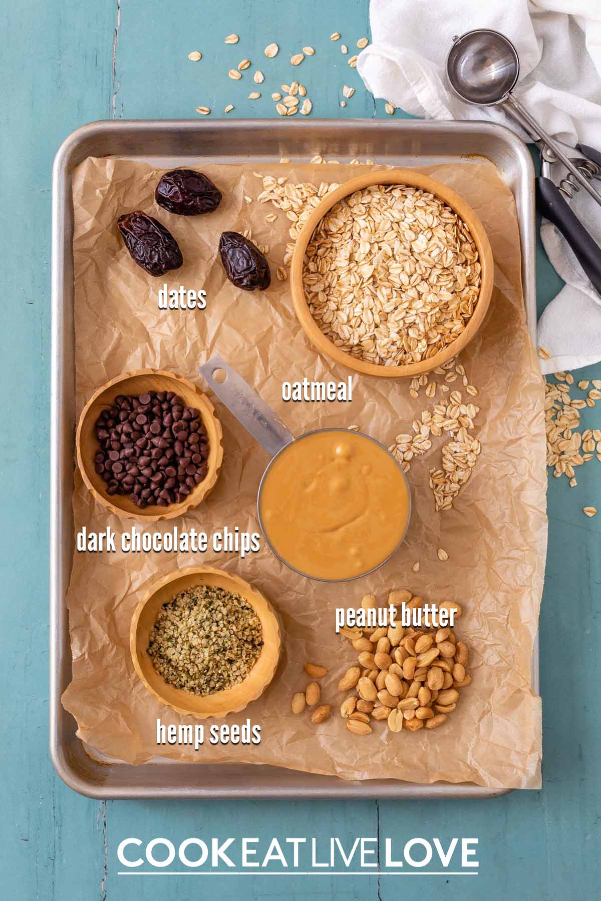 Ingredients to make peanut butter balls on a baking tray lined with parchment paper.