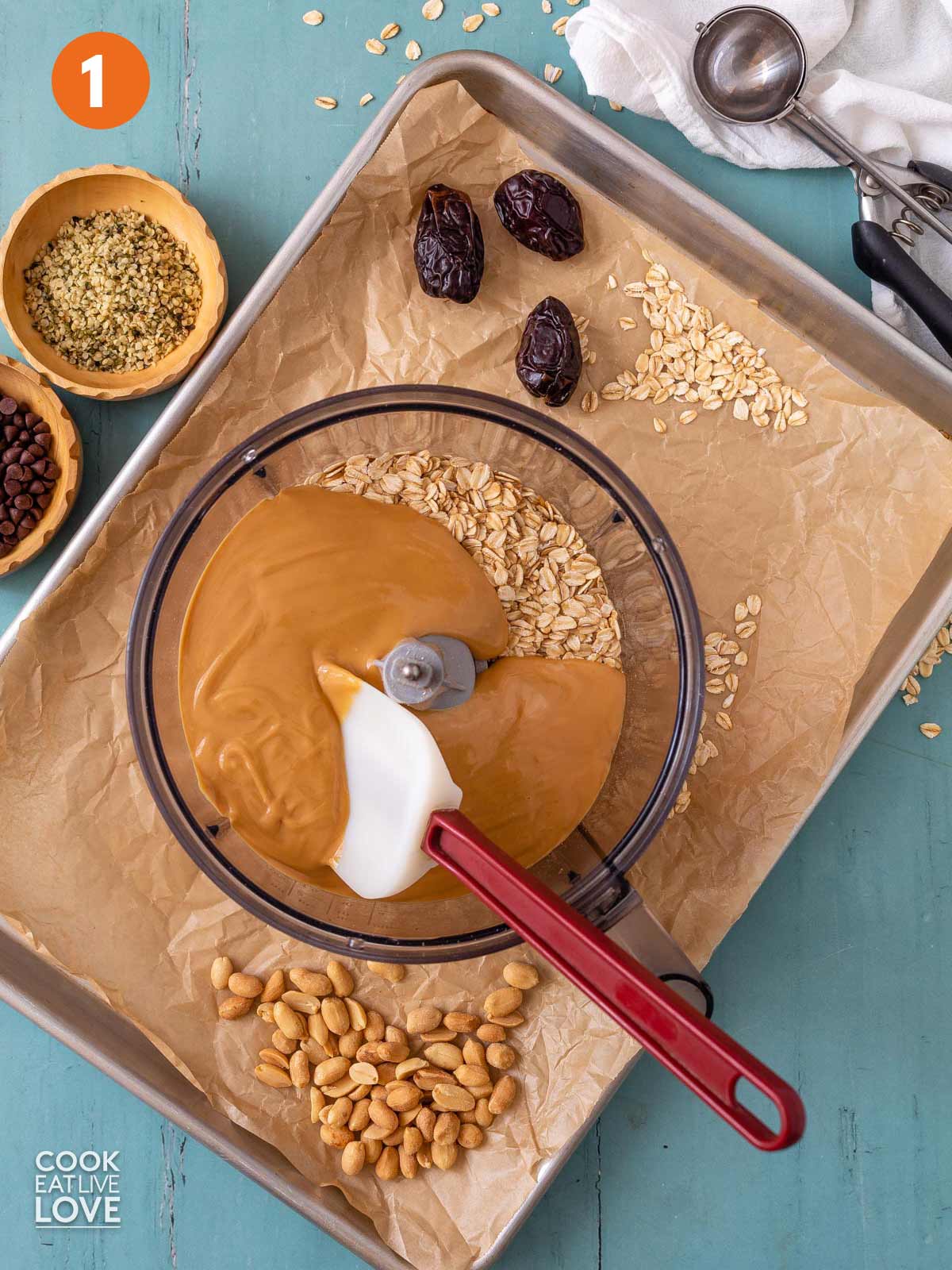Peanut butter and oats in a food processor bowl.