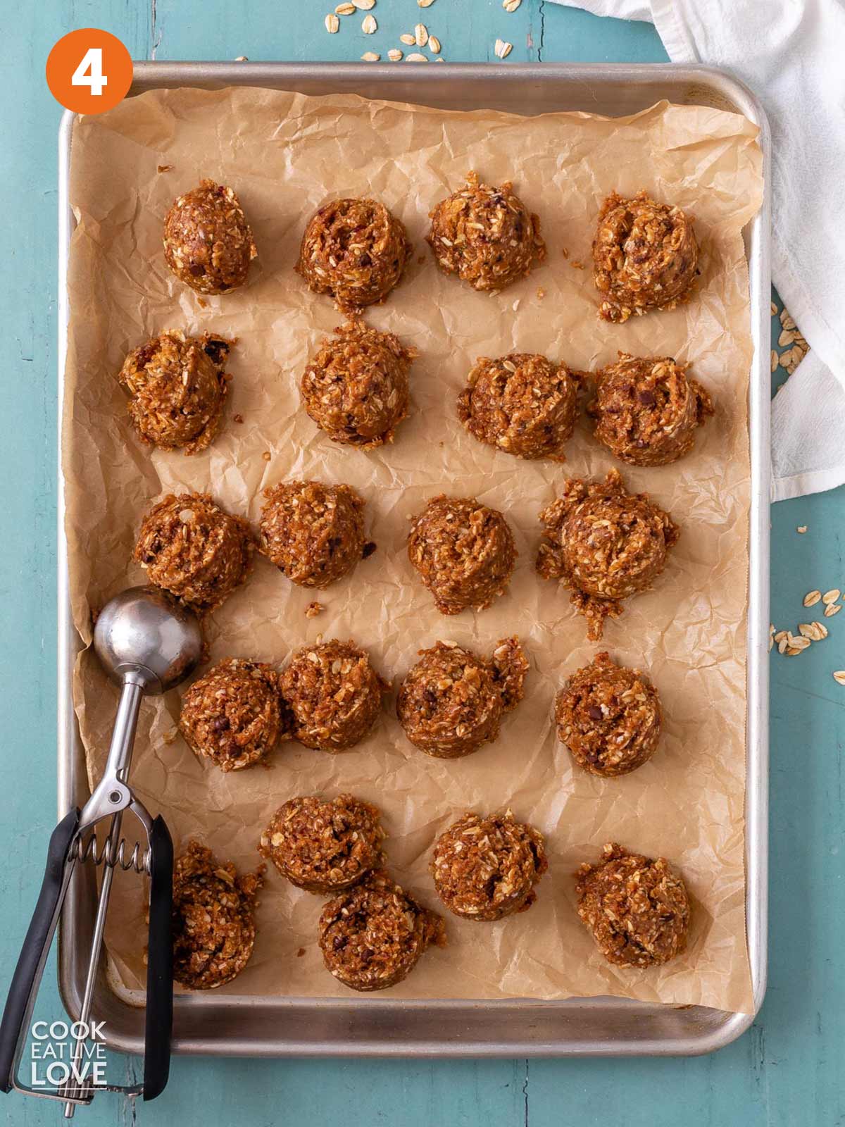 4 ingredient peanut butter balls scooped onto a baking sheet with a scoop on the side.