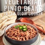 Pin for pinterest graphic with image of pinto beans in a bowl in front of a slow cooker with text on top.
