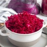 Pin for pinterest graphic with image of red cabbage sauerkraut in a bowl with text on top.