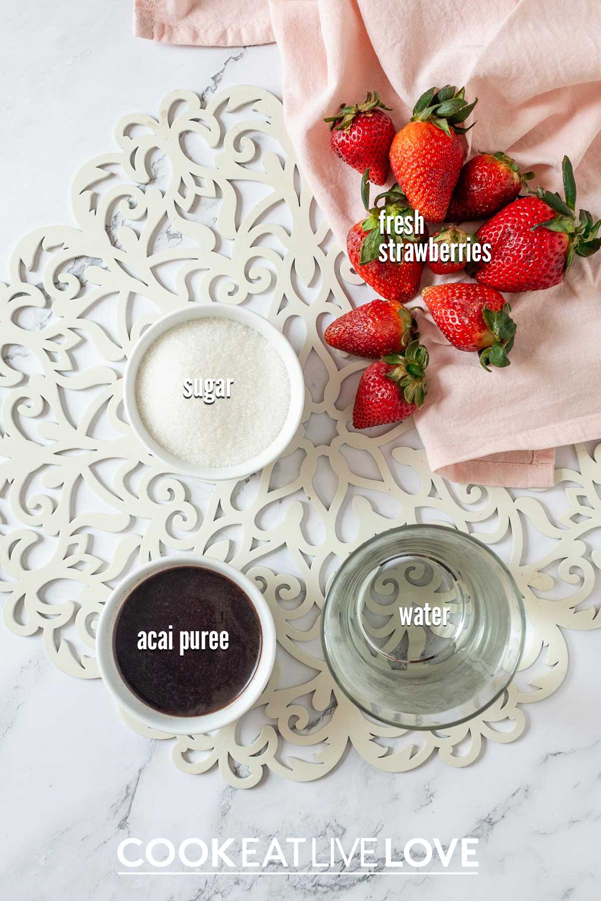 Ingredients to make strawberry acai syrup on the table with text on top.