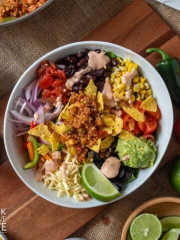 Bowl of vegan taco salad with tofu taco meat on a table.