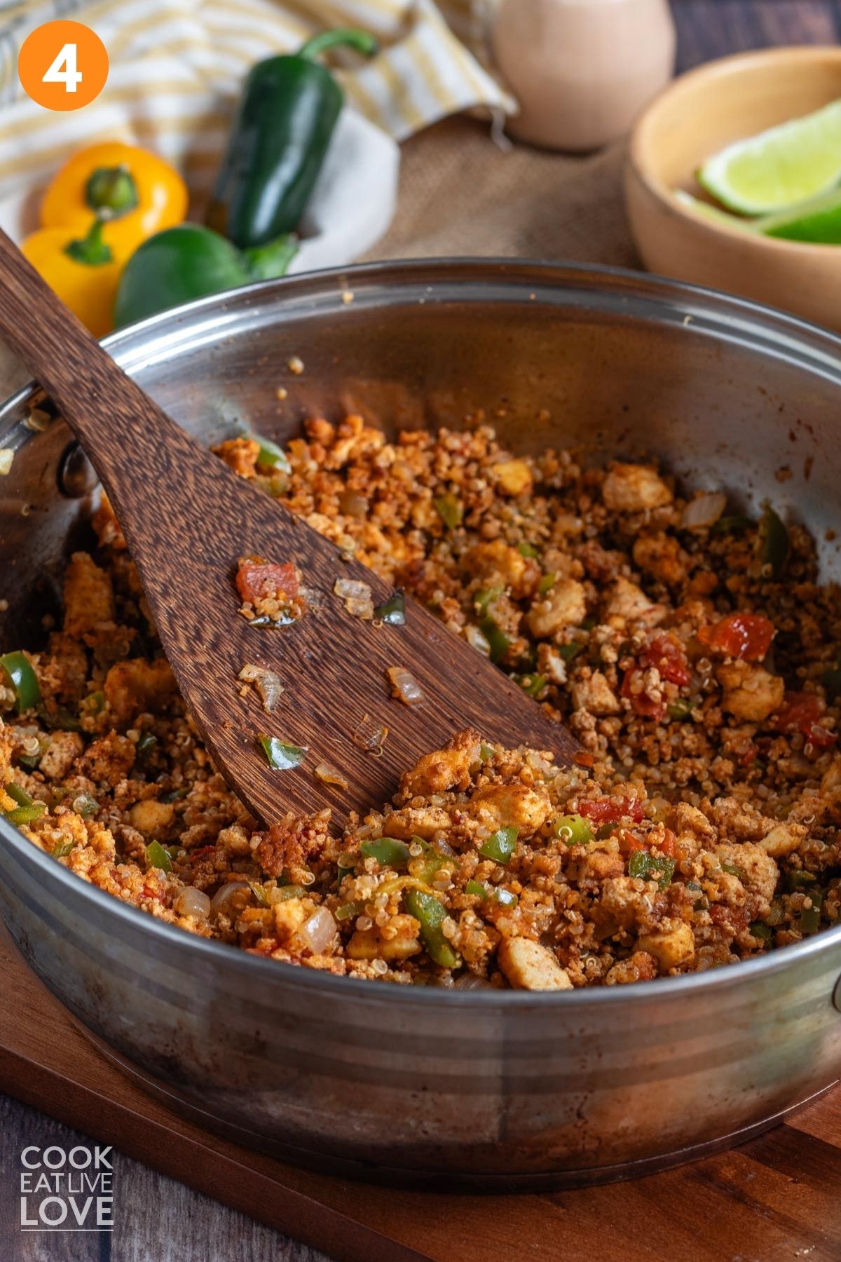 Tofu taco meat cooked in a skillet with a wooden spoon resting to the side. 