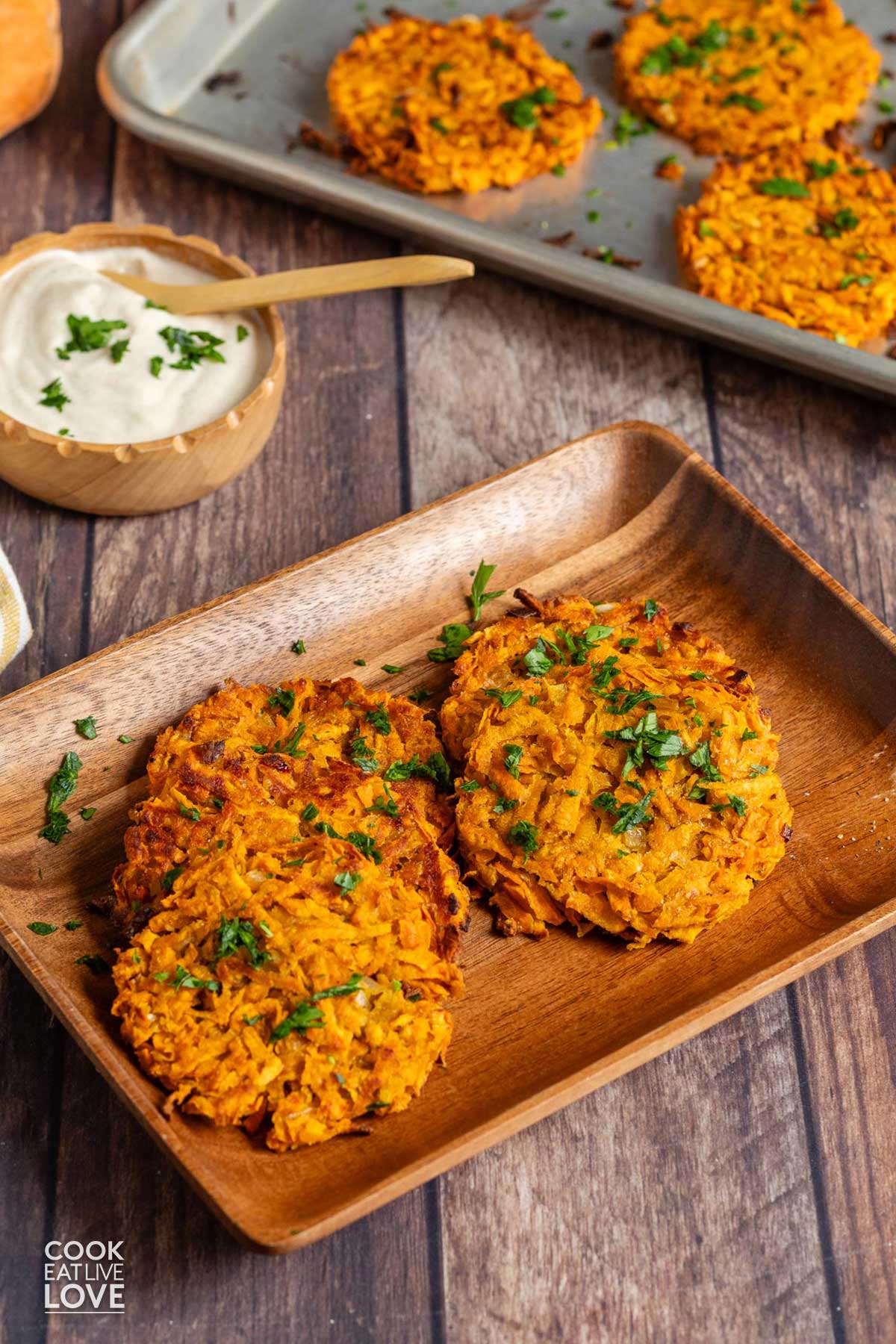 Sweet potato hashbrowns on a wooden tray with more in the background.