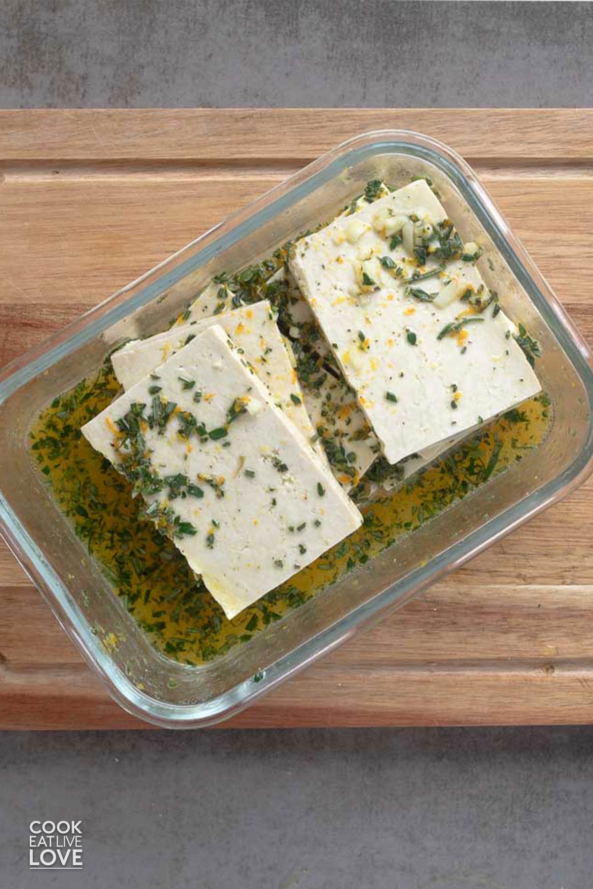 Sliced tofu in a glass dish with marinade poured over it.