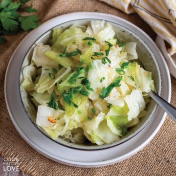 Instant pot cabbage in a bowl with a spoon on the side.
