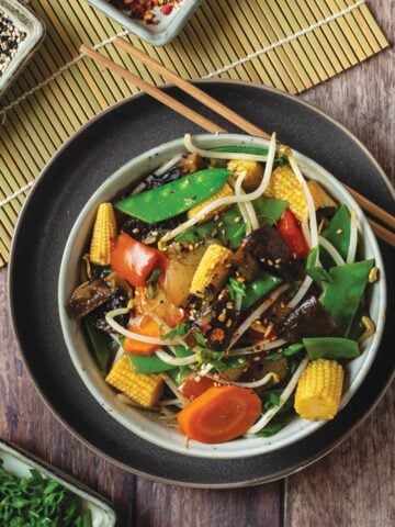 Instant pot stir fry vegetables in a bowl with chopsticks off to the side.