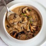 A bowl of vegan mushroom sauce with a spoon resting in the dish.