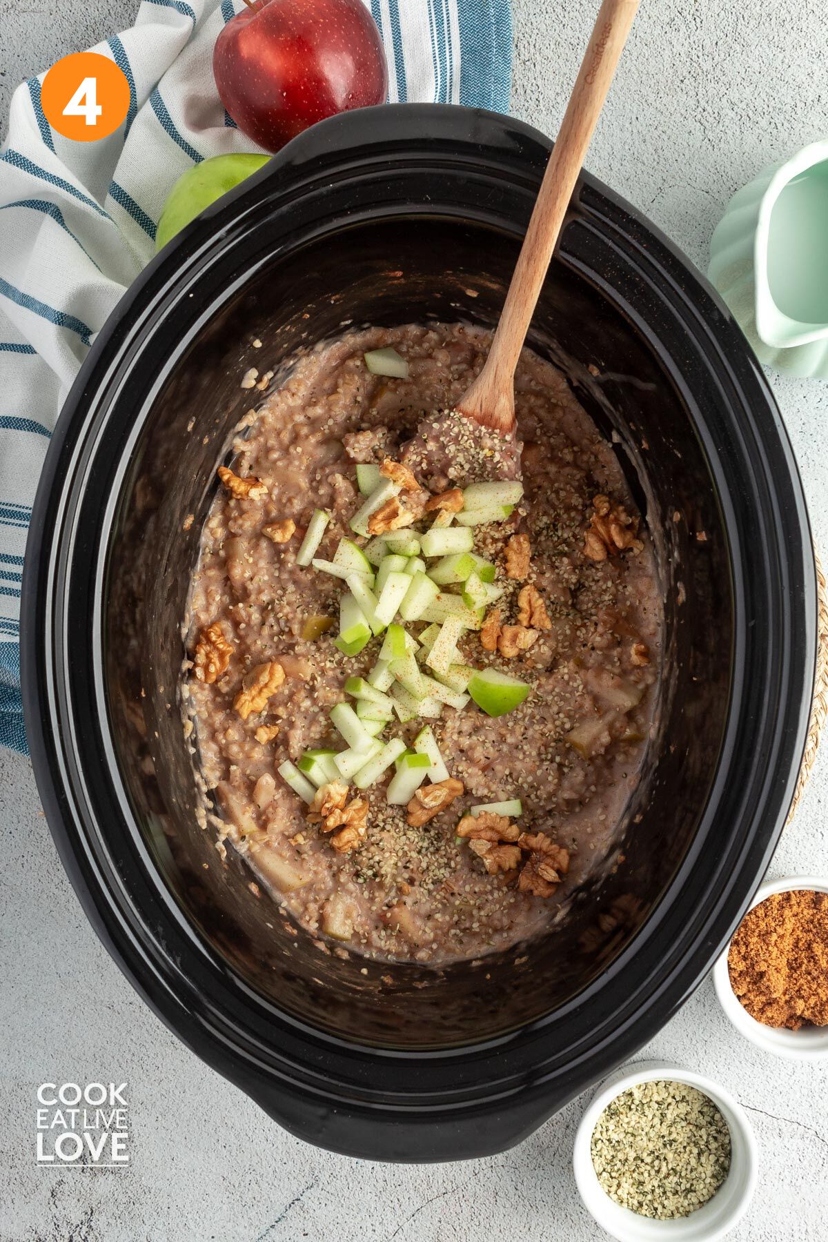 Apple oatmeal cooked in the slow cooker and garnished with diced apples and walnuts.