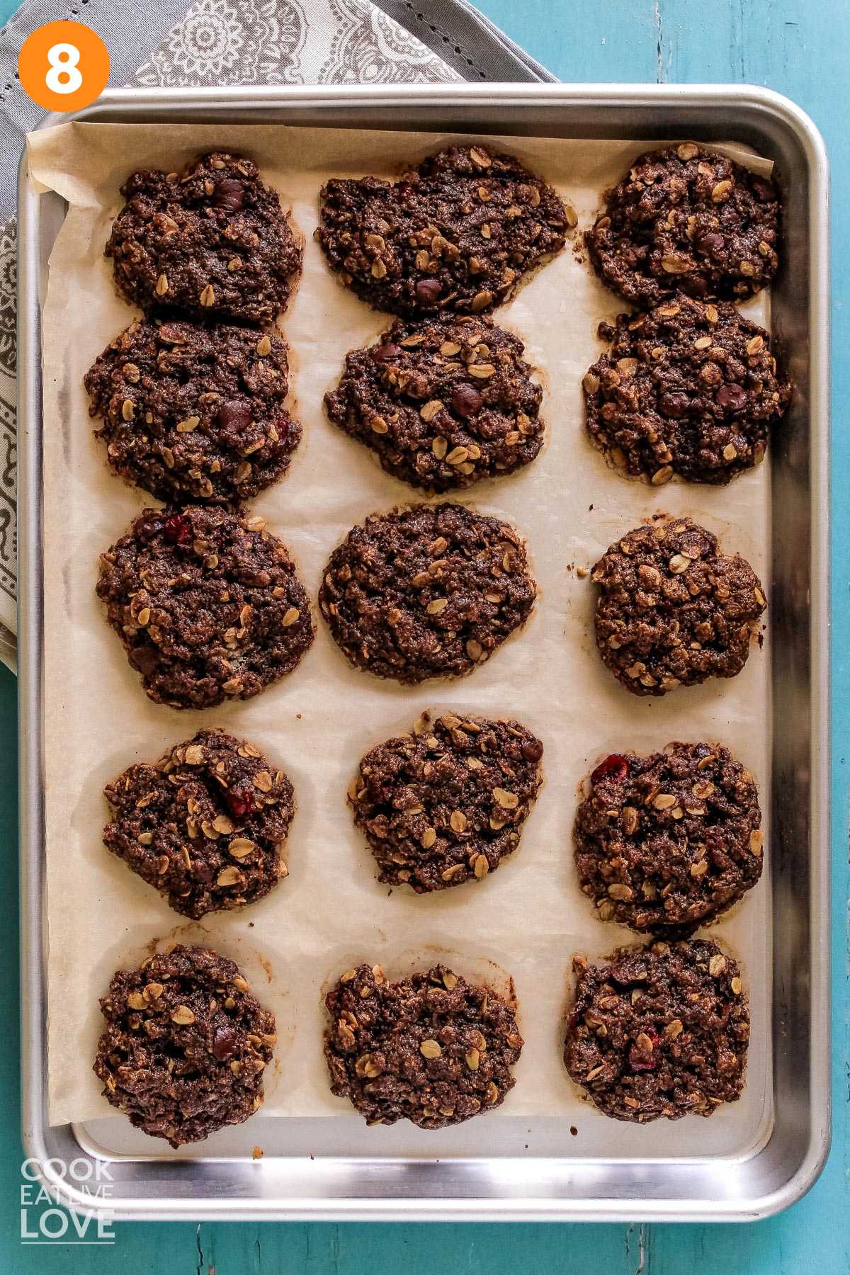 Baked vegan chocolate oatmeal cookies on a baking pan.