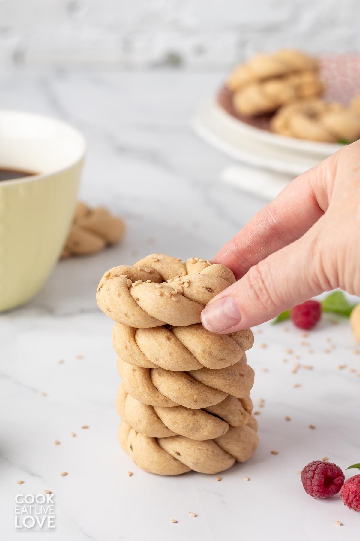 A stack of Peruvian anise cookies with a hand reaching to grab one.