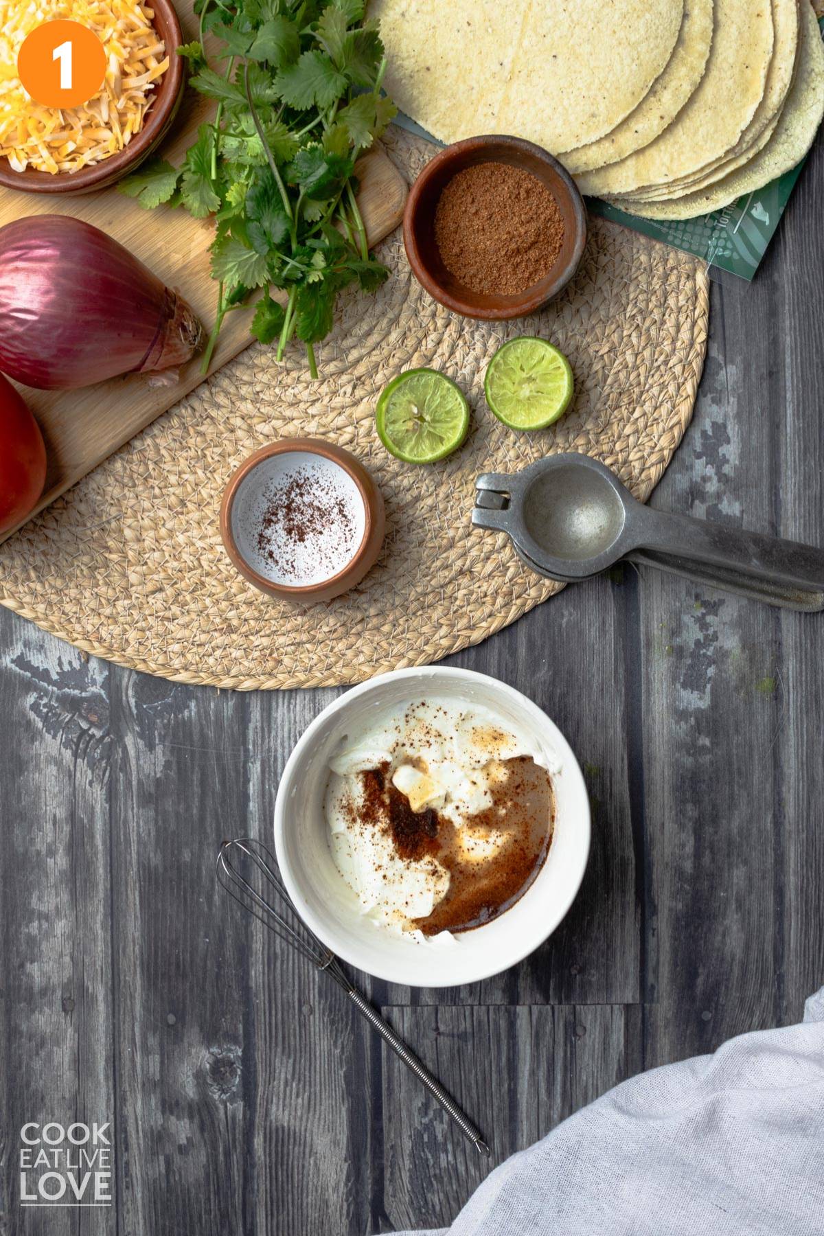 A small white bowl with greek yogurt and seasonings to make dip.