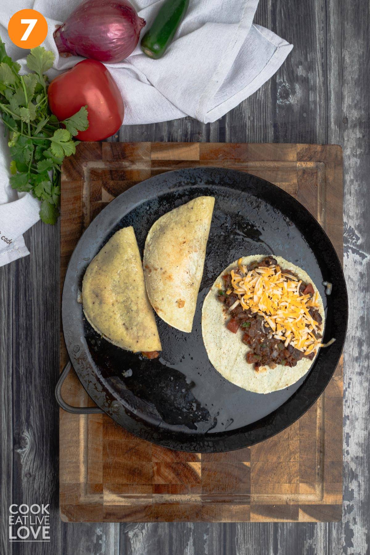 Cooking black bean tacos on a comal.