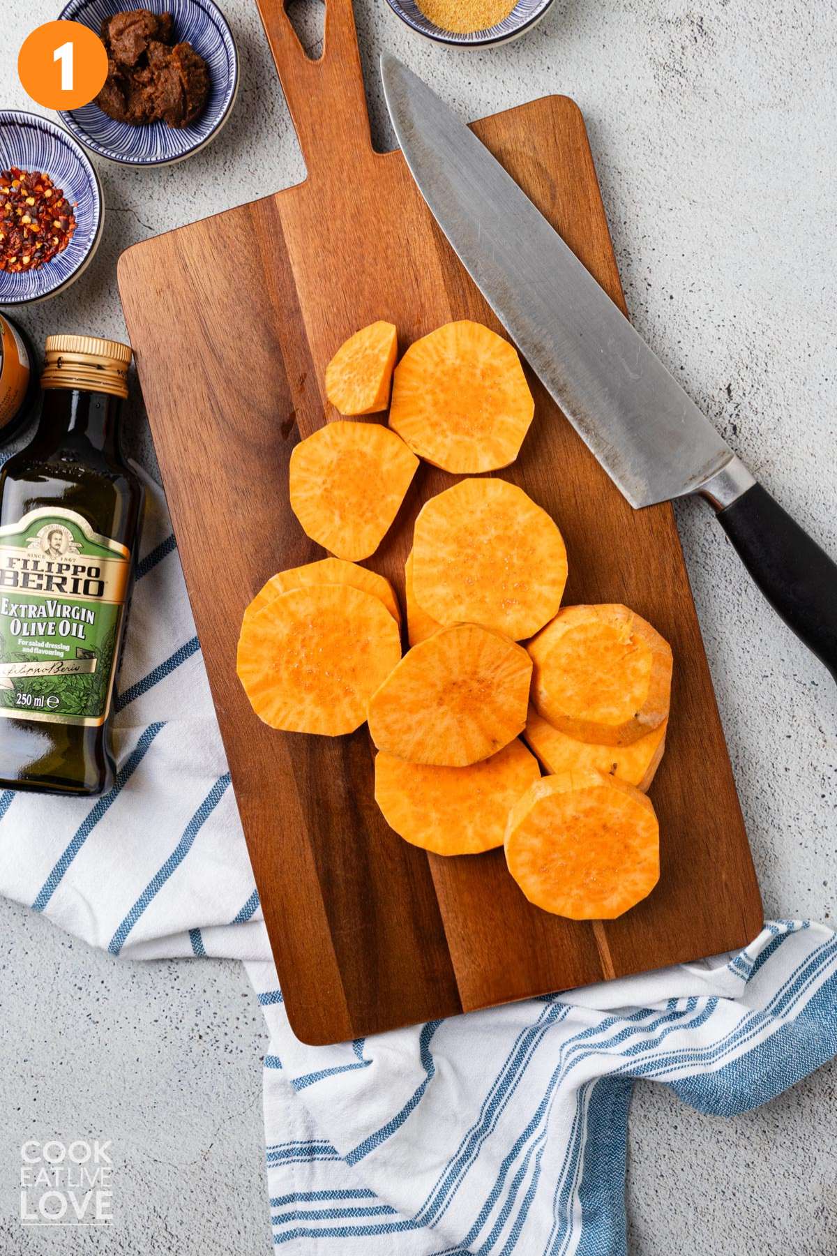 Sweet potatoes sliced into rounds on a cutting board.