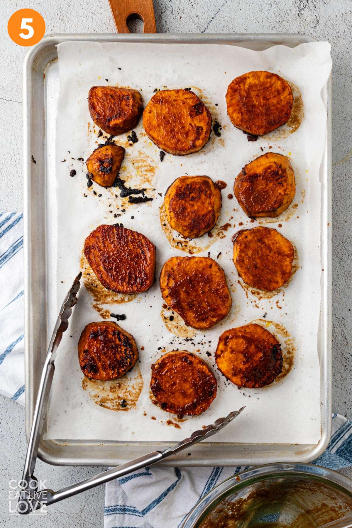 Partially baked sweet potatoes with a pastry brush and empty bowl of marinade to the side.