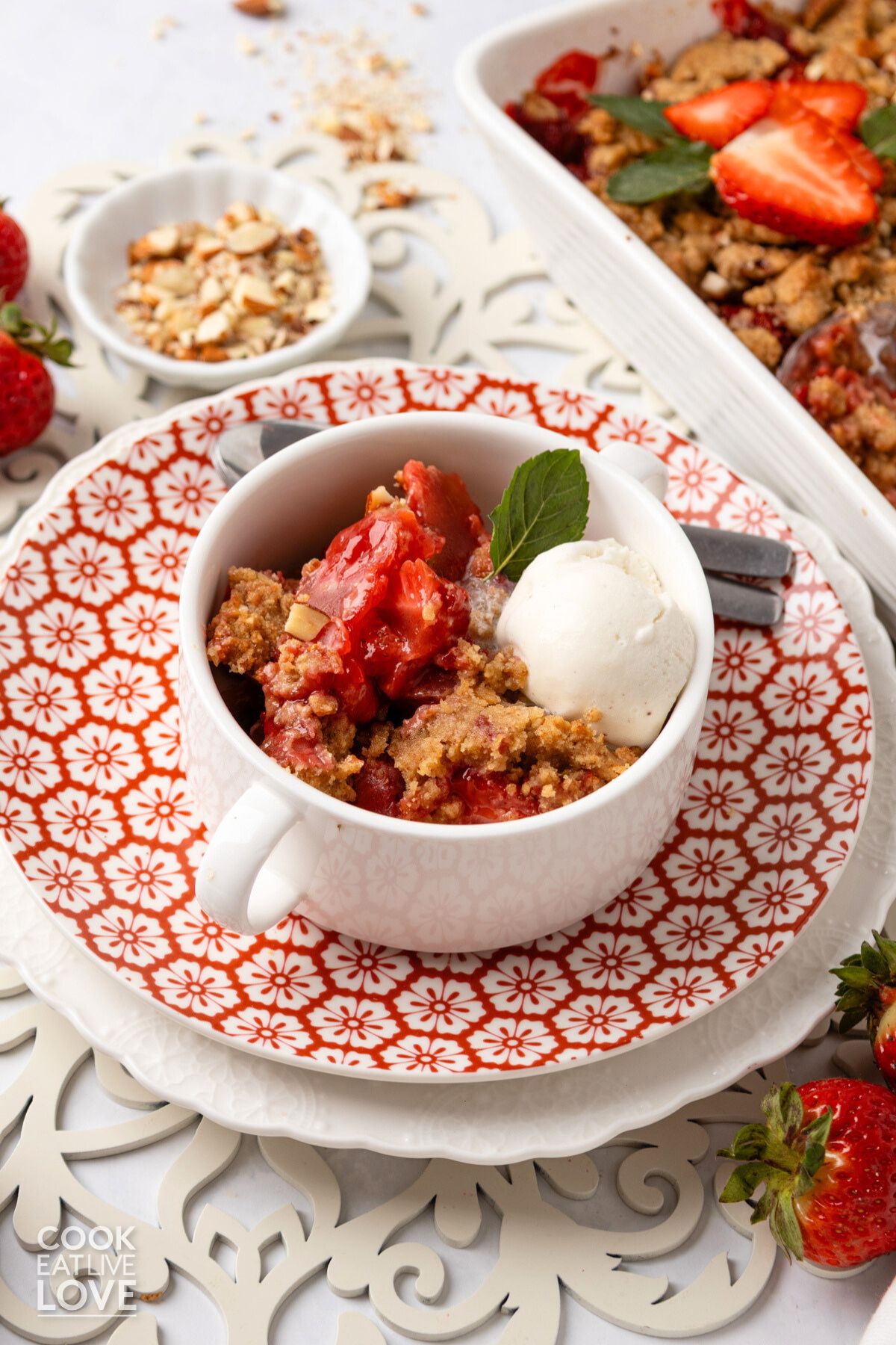 Strawberry crumble in a white dish with a scoop of ice cream.
