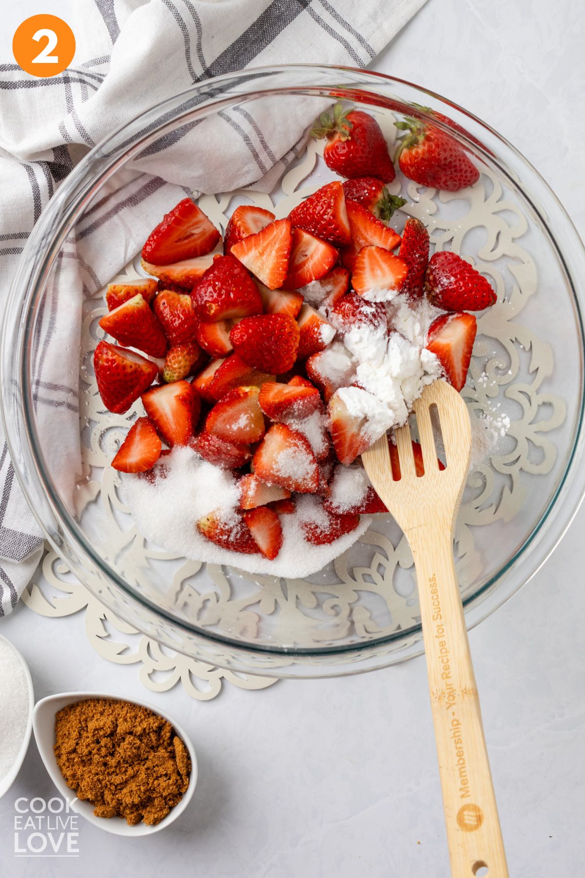 Strawberries in a large bowl with cornstarch and sugar.