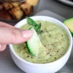 Pin for pinterest with image of avocado dressing in a bowl and text on top.