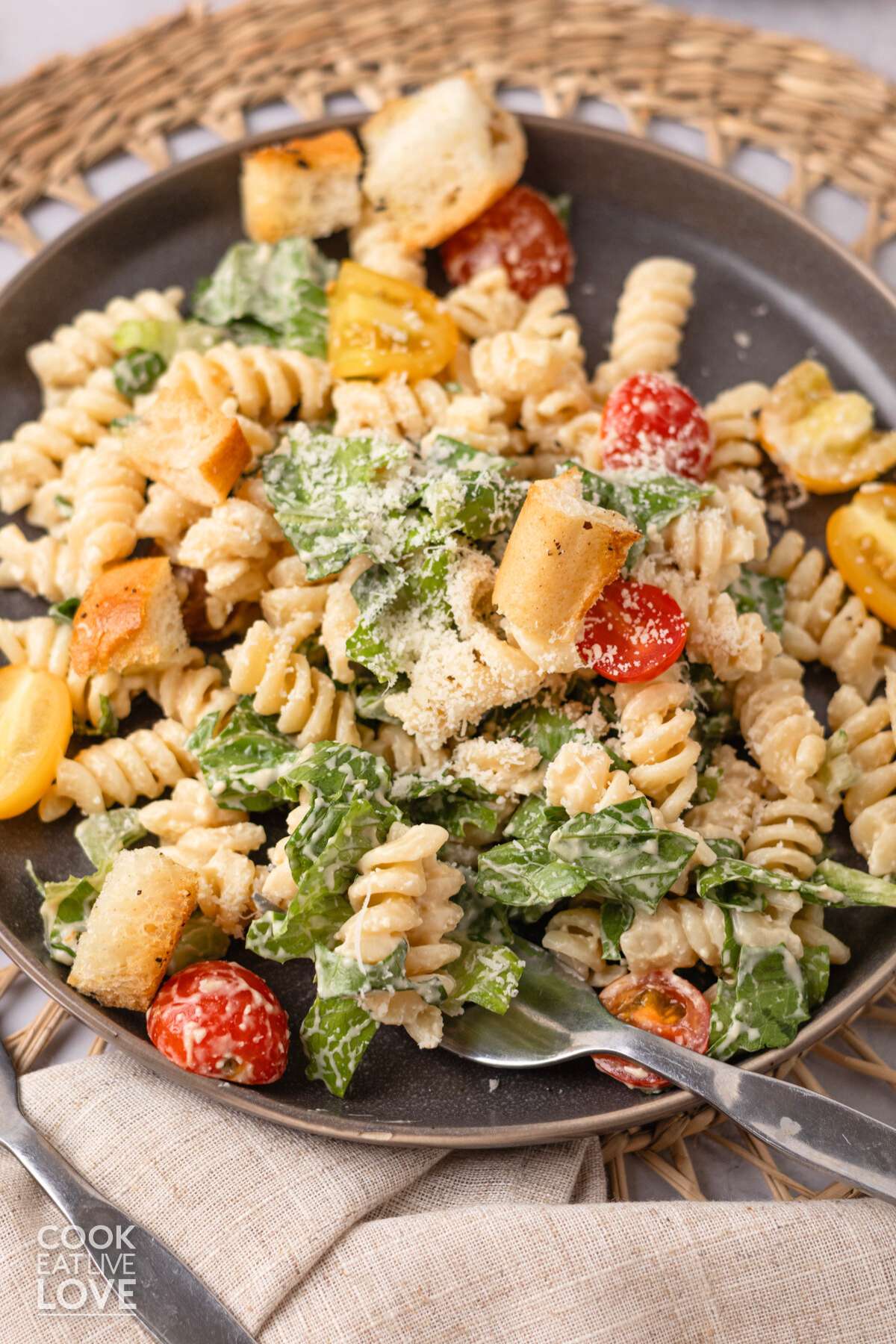 A plate of Caesar pasta salad with a fork resting on the edge.
