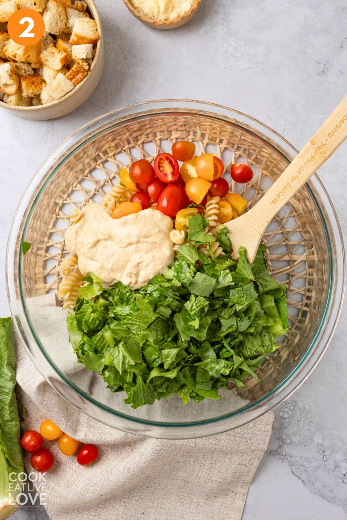 Ingredients for a Caesar pasta salad in a bowl.
