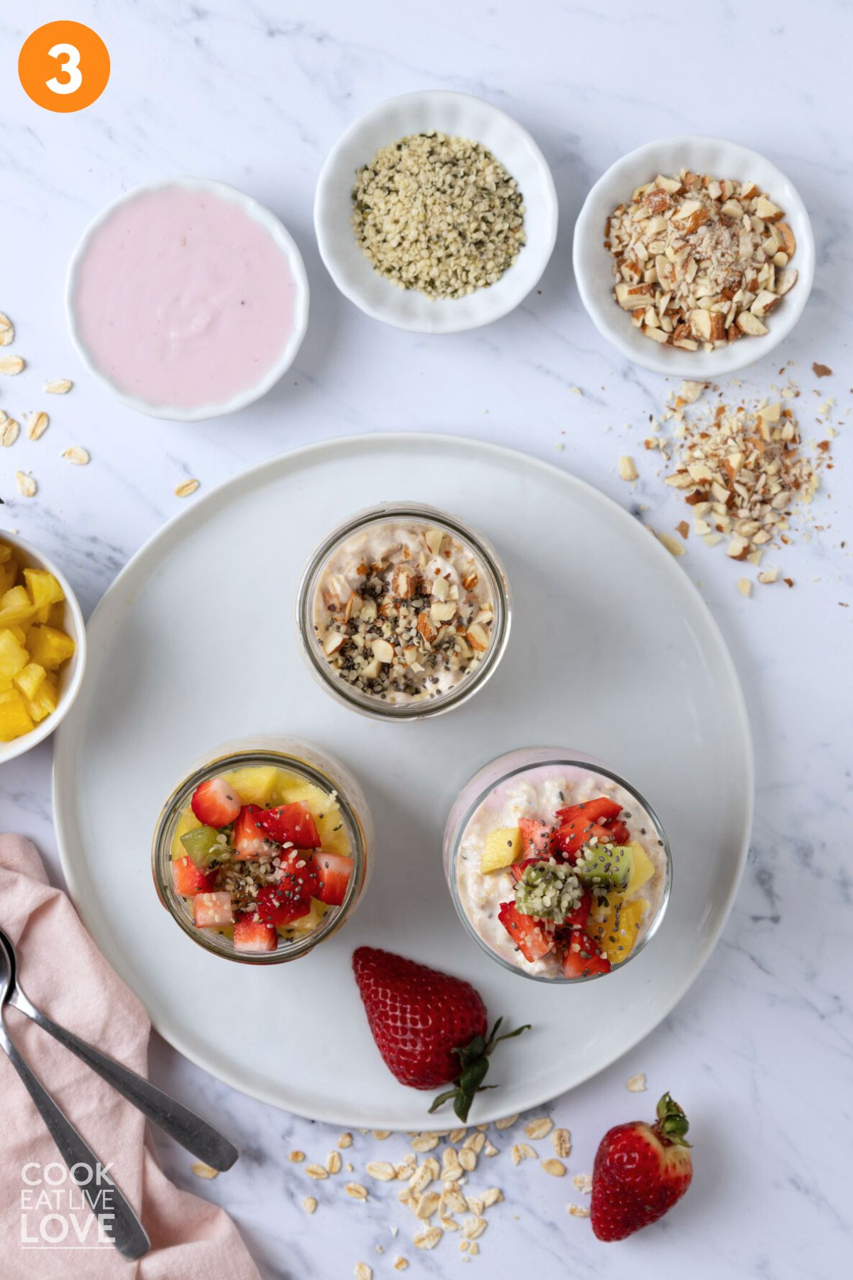 Overnight oats with Greek yogurt on white plate with different toppings.
