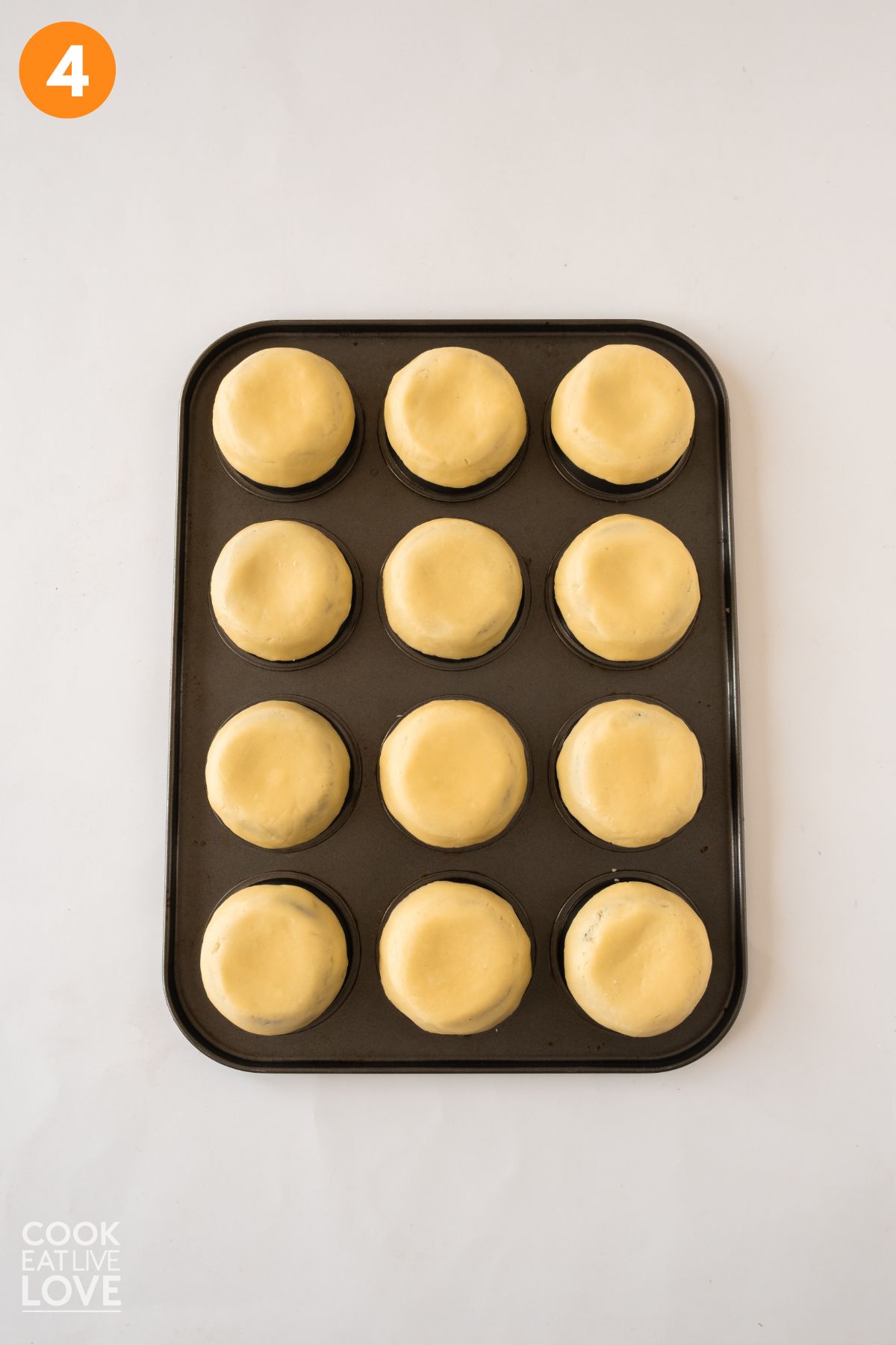 Dough shaped to form crusts on a mini muffin pan flipped upside down.