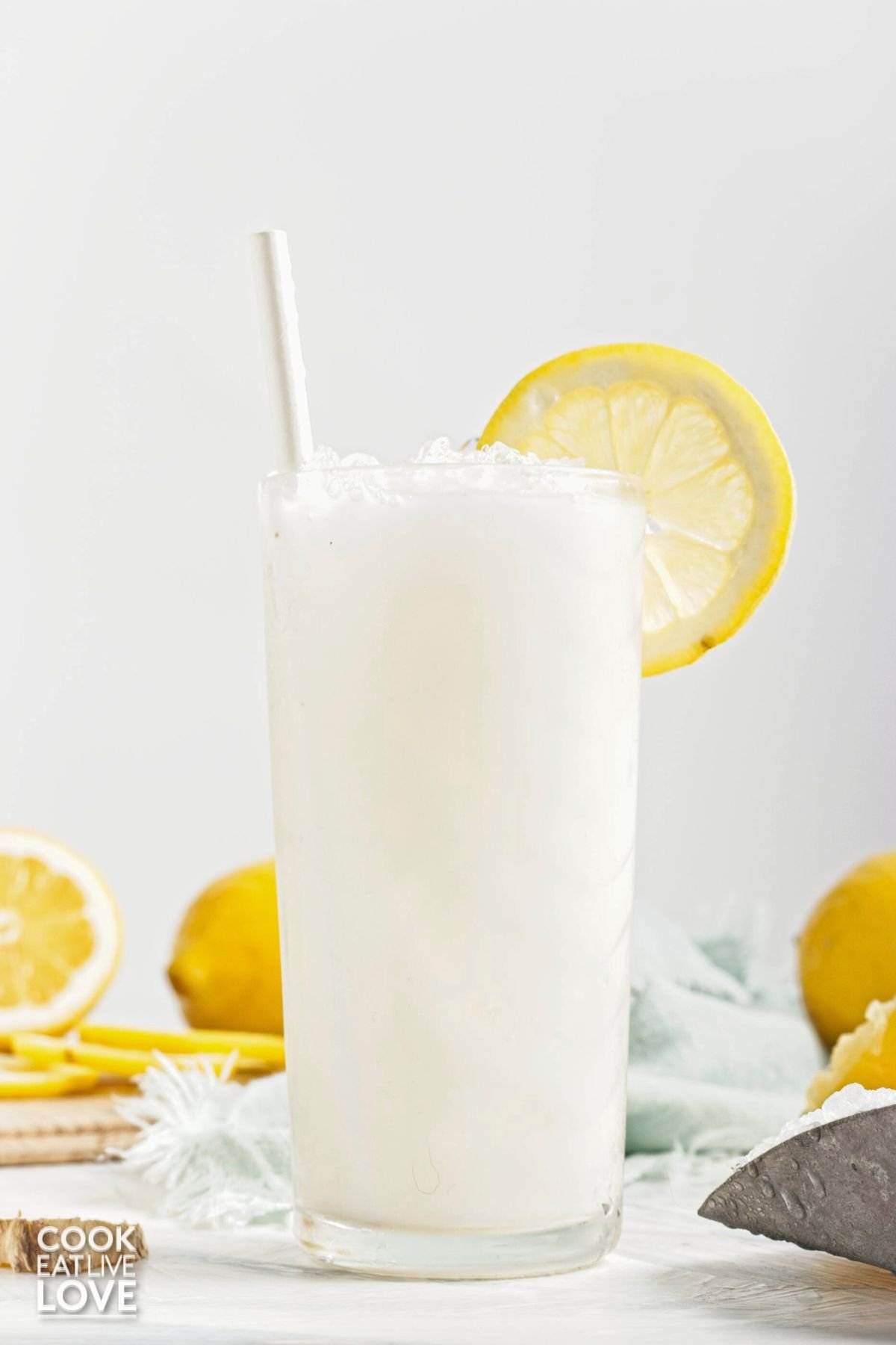 Coconut lemonade poured into a glass with a lemon wheel garnish.