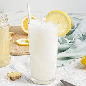 Creamy coconut lemonade in a glass over ice with lemon slices.
