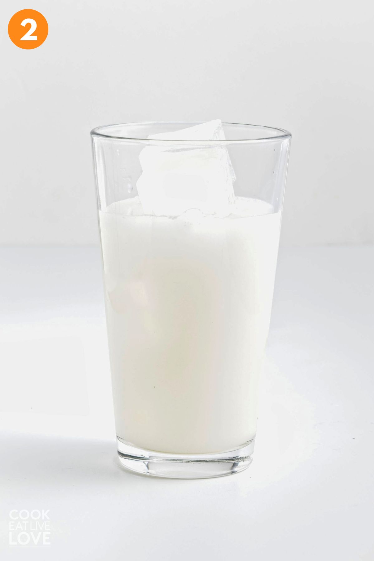 Ingredients to make coconut lemonade added to a glass with ice.
