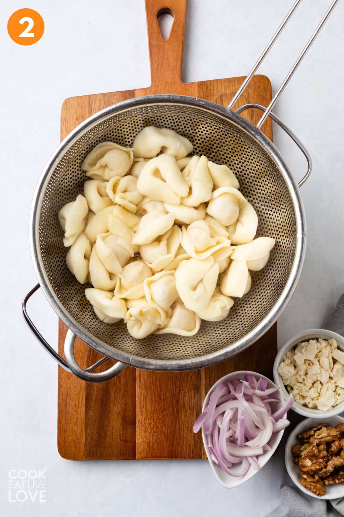 Tortellini draining in a strainer after cooking.