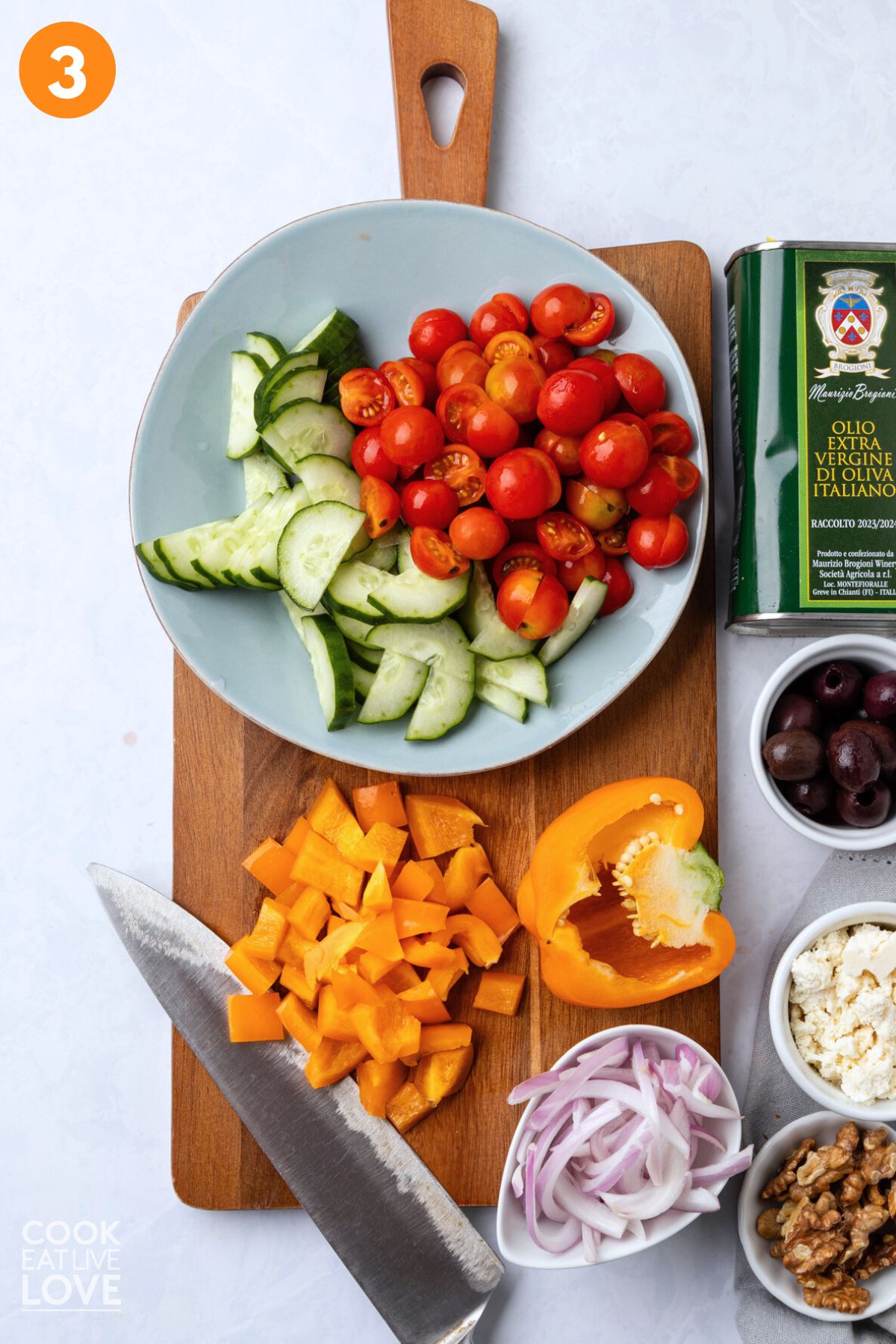 Vegetables for Greek tortellini salad chopped on a cutting board.