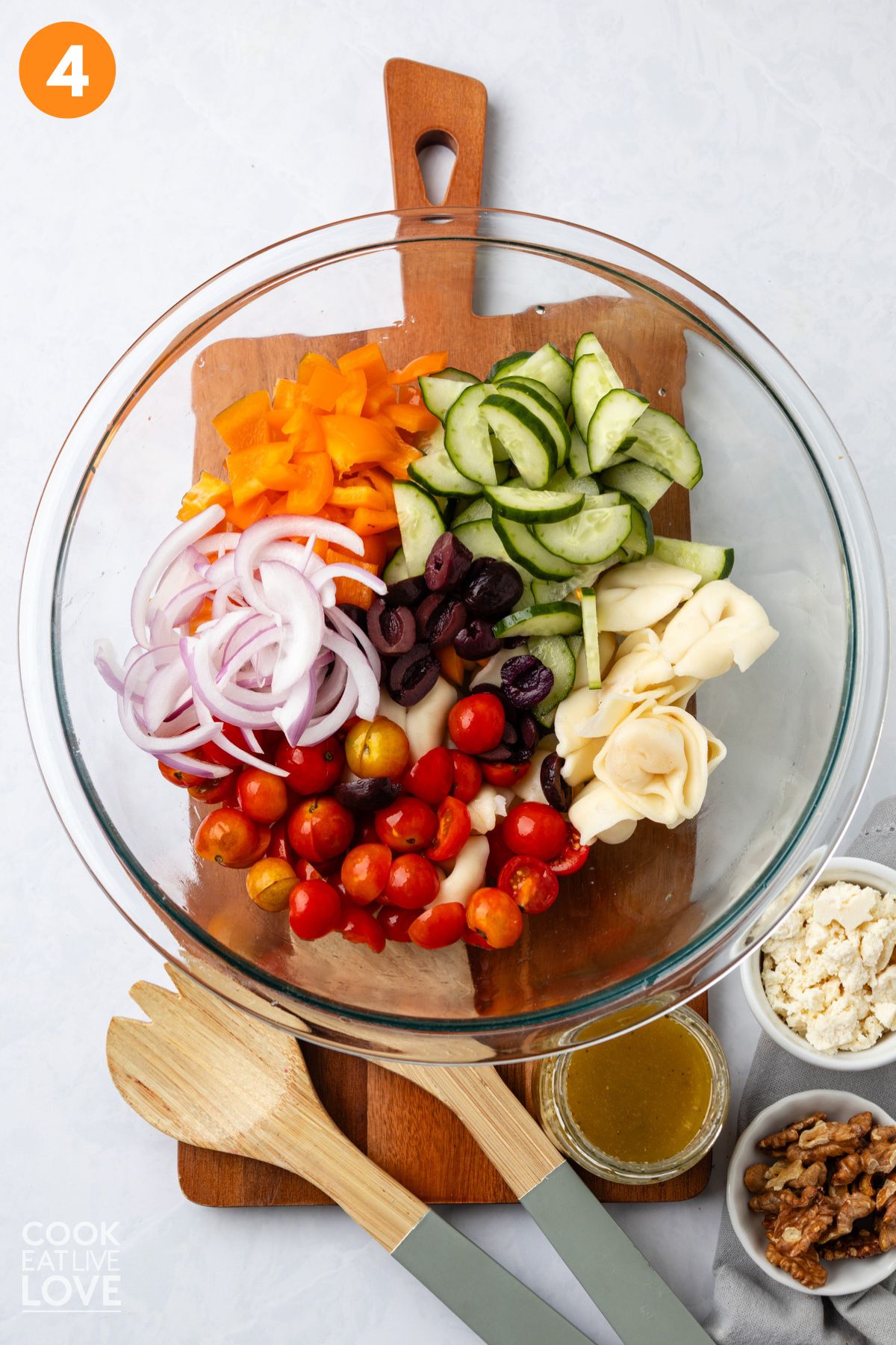 Greek tortellini salad ingredients in a large mixing bowl.
