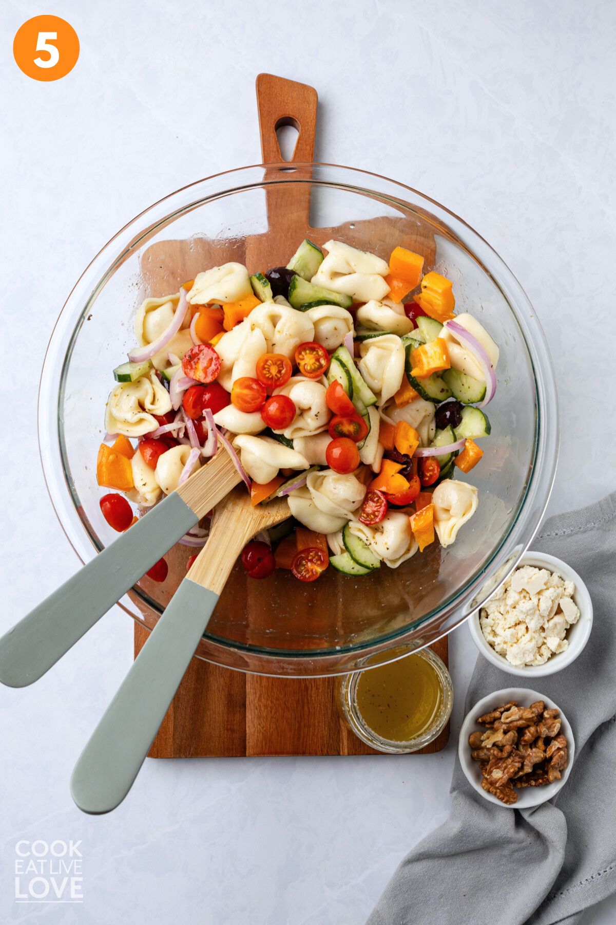 Greek tortellini salad tossed together in a bowl.