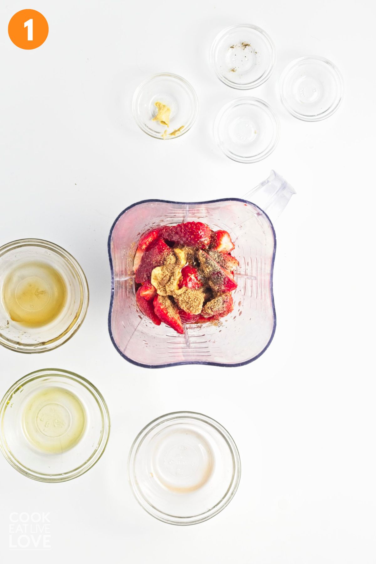Ingredients to make the strawberry salad dressing in a blender.