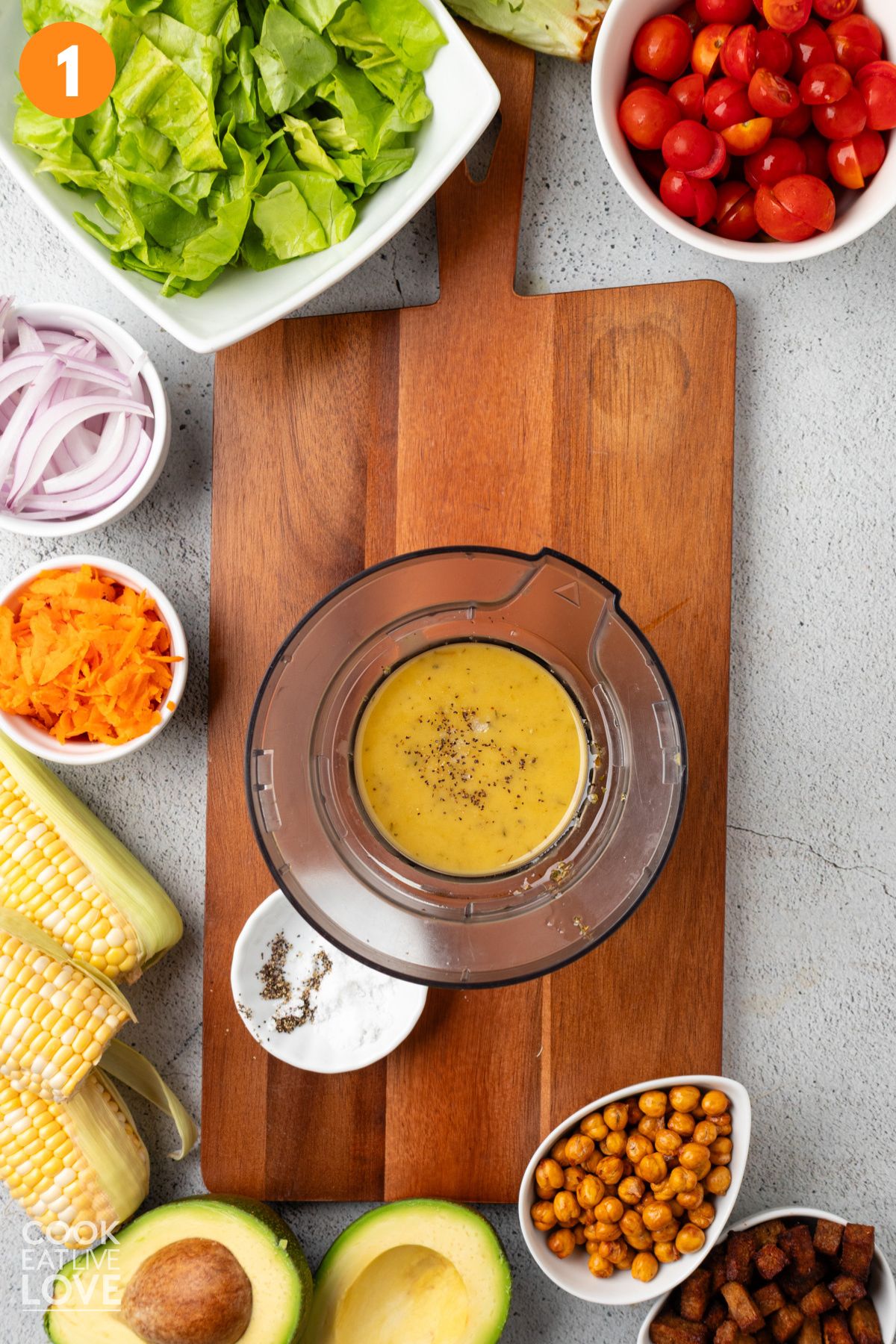 Cobb salad dressing in a blender on a cutting board.