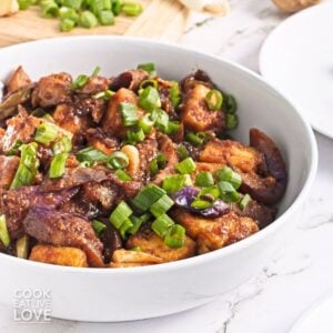 A bowl of eggplant tofu garnished with green onions.