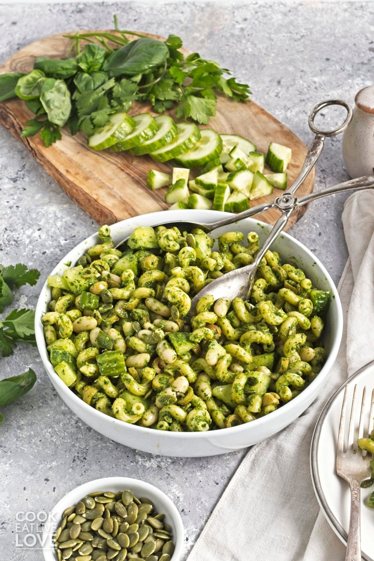 Green goddess pasta salad in a bowl with salad tongs in the dish to serve.