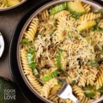 A bowl of lentil zucchini pasta with a fork resting in the side.